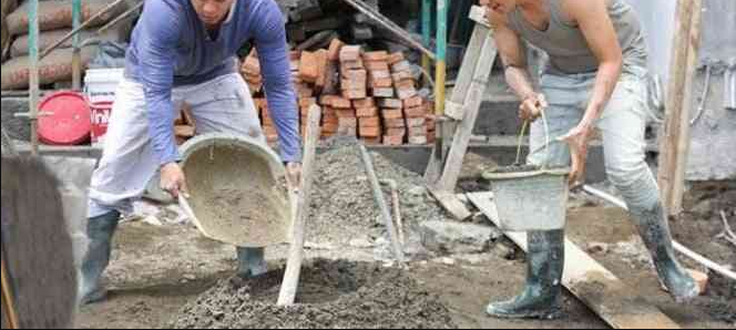 Workers preparing construction material